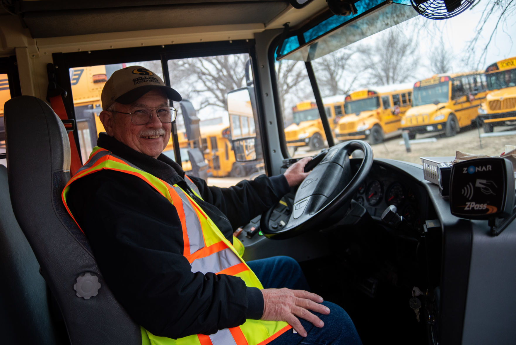 Dale Hayden sits in the driver's seat of his school bus while in the parking lot at the USD 383 Transportation Department.
